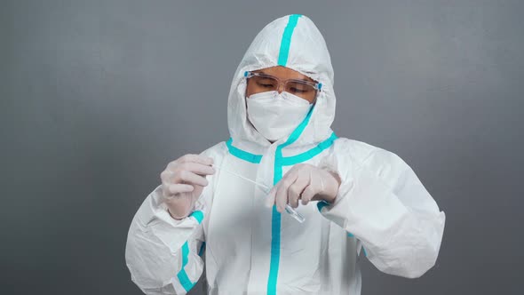 male doctor in protective suit PPE holding Coronavirus(COVID-19) Nasal swab laboratory test