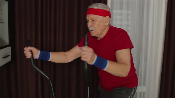 Senior Man in Sportswear Using Orbitrek in Living Room Doing Sport Training Cardio Exercises at Home alt