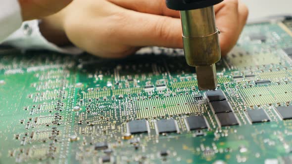 Electrician Repairing Motherboard Chips By Desoldering