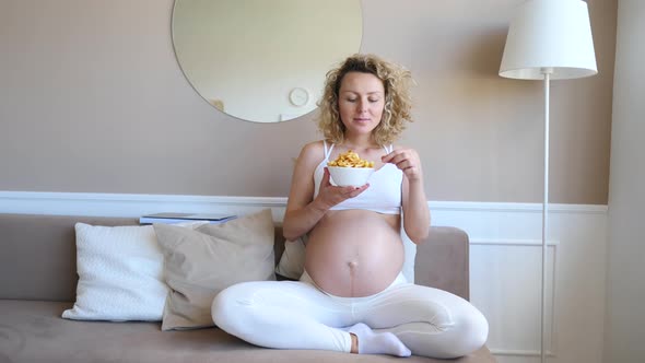Pregnant Girl With Fast Food Fried Potatoes In Comfortable Home Environment alt
