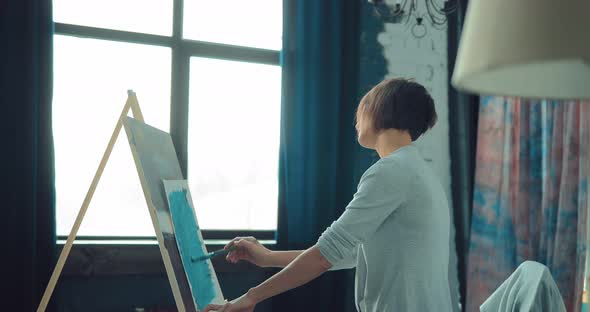 Young Girl is Inspired By Her Hobby Draws at the Easel alt