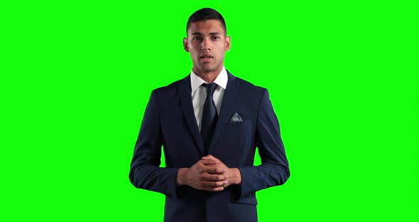 mixed race man in suit talking in a green background