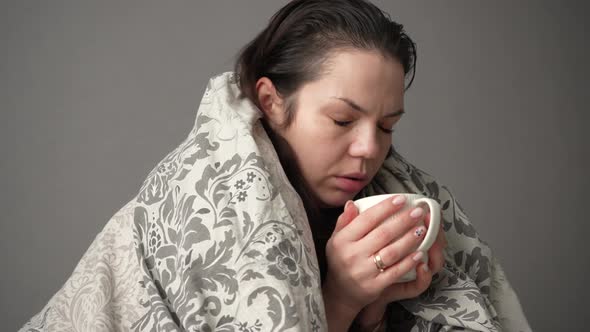 Portrait of Sick Tired Woman Patient with White Cup Sitting on Sofa