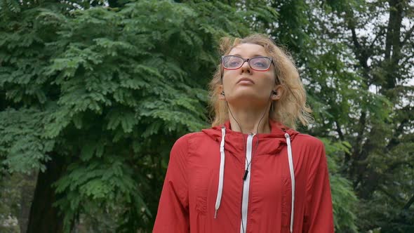 Sportive Fitness Girl in Eyeglasses is Warming Out Ready to Exercise Outside in the Park During alt