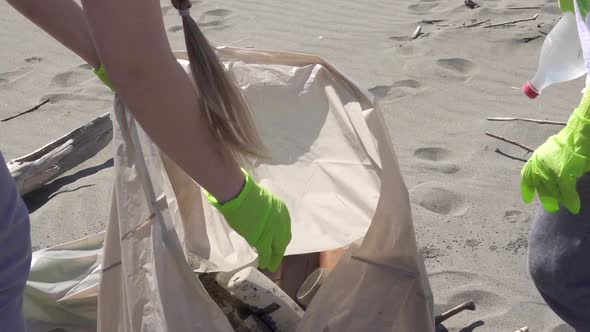 Family Picks Up Trash From the Beach in Trash Bags