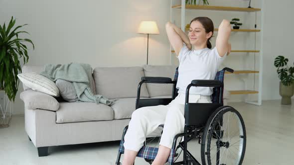Young Woman is Spreading Her Arms in Different Sides in Wheelchair alt