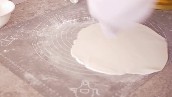 Confectioner Rolls Out Dough Mastic for Decorating Cake Pastries