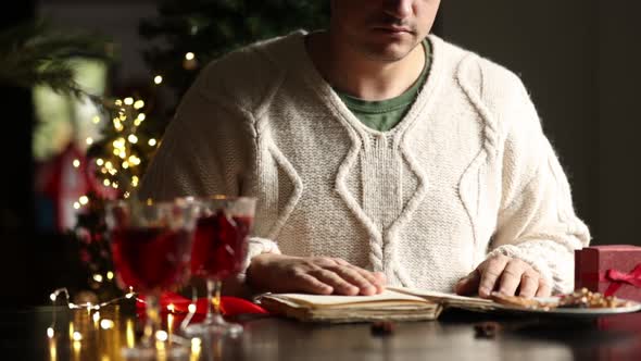 man sitting at the Christmas table and reading a book