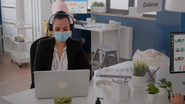Freelancer with Protective Face Mask Wearing Headset While Talking Into Microphone alt