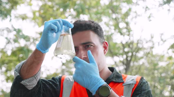 Biological engineer check contaminants in factory wastewater in a test tube