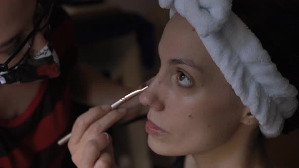 Makeup artist applying concealer on clients lower lid alt