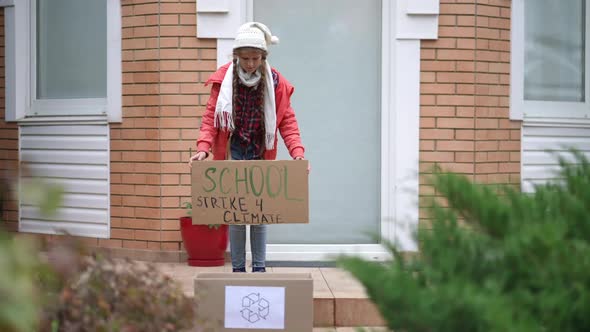 Wide Shot Teenage Girl with School Strike for Climate Banner Walking to Box with Recycle Symbol in alt
