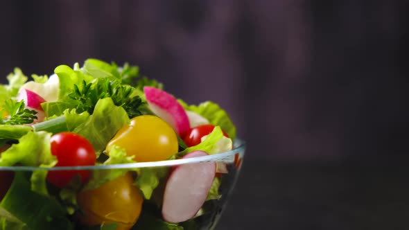 Fresh vegetable salad from cucumber, tomato and lettuce on black background alt