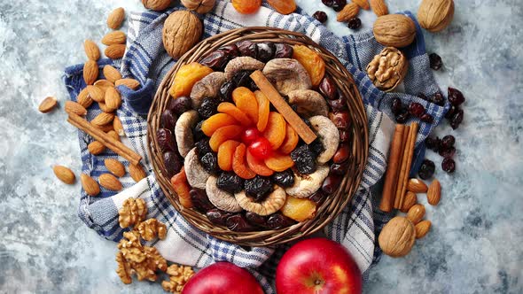 Composition of Dried Fruits and Nuts in Small Wicker Bowl Placed on Stone Table alt