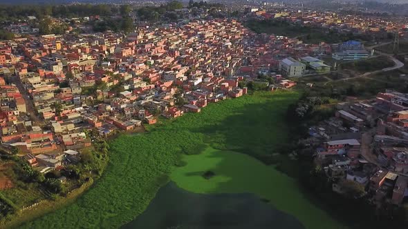 Beautiful cinematic aerial footage over the lake and favelas in Sao Paulo, Brazil alt