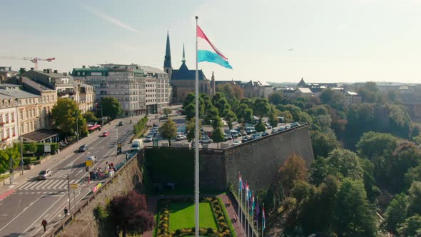Establishing Aerial Shot of Luxembourg Cityscape with Landmark National Flag