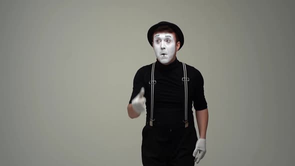 Portrait of Male Mime Flipping Imaginary Coin Remains Dissatisfied with Result and Flips Coin Again alt