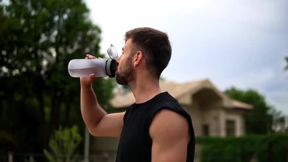 Portrait of Thirsty Sport Man Drinking Mineral Water After Outdoor Workout alt