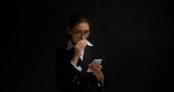 Business Woman Flips Through a News Feed in a Messenger and Vapes