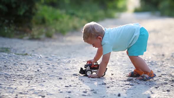 Baby plays a toy car on the road