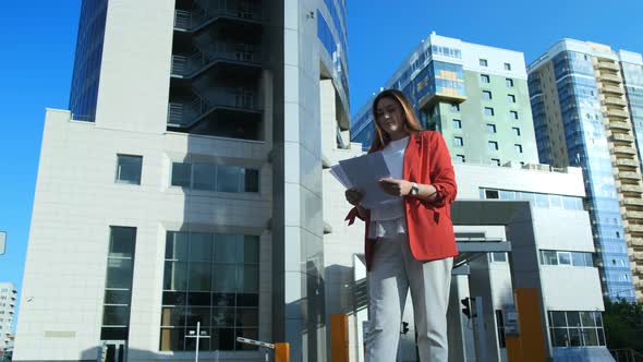 Businesswoman in Red Jacket Throws Paper Documents alt