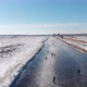 People ice skating on frozen canals in Netherlands, 4K winter aerial view