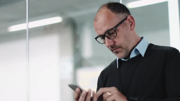 Architect using phone in contemporary office