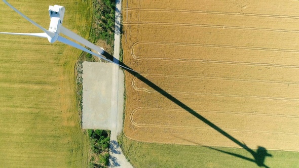 Windmill for electric power production in the agricultural fields. View from above. alt