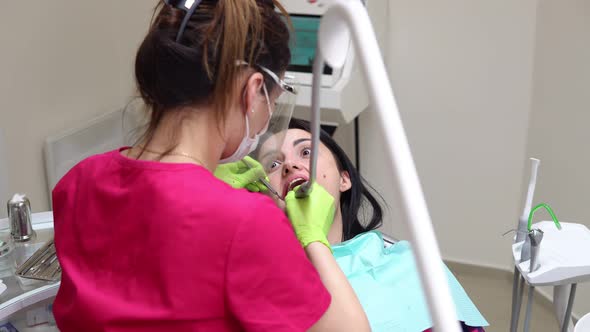 Dentist Cleans Woman's Teeth with Professional Toothpaste and Automatic Brush alt