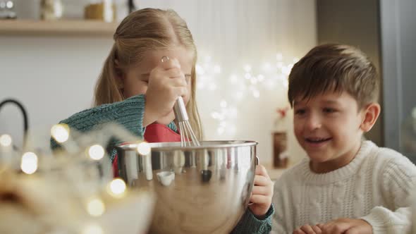 Video of sibling having fun while preparing Christmas cookies. Shot with RED helium camera in 8K. alt