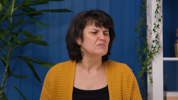 Middle Aged Woman Frowns at the Bad Smell in the Room alt