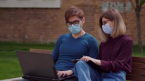 Two professional coworkers in protective mask discuss alt