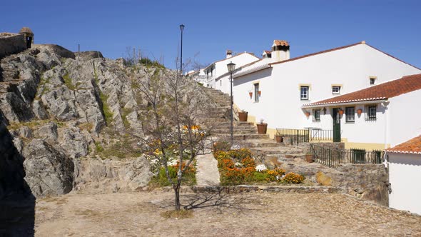 View of Marvao village with beautiful houses and church with rocky landscape mountains behind alt