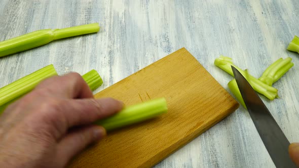 Cutting around the edges of fresh celery stalks before cooking