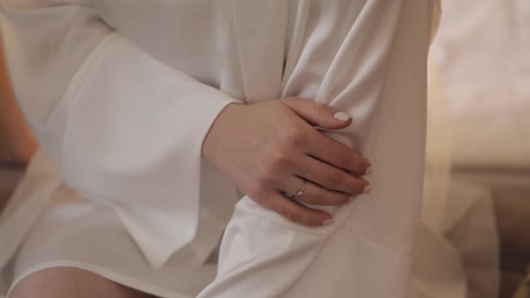 Hand with Engagement Ring Closeup Wedding Bride in Night Gown and Veil Sitting at Home Room alt