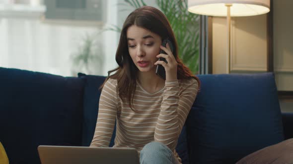 Attractive Young Woman is Speaking on Smartphone with Client From Home alt