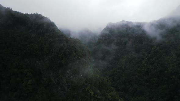 Aerial View Of Mystical Green Mountains Valley Landscape Covered With Clouds Or Fog
