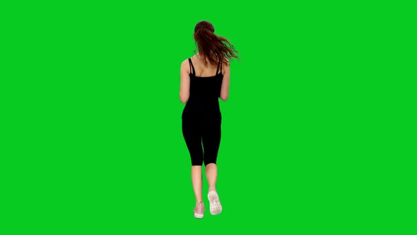 Rear View of Young Sporty Woman Jogging on Green Screen