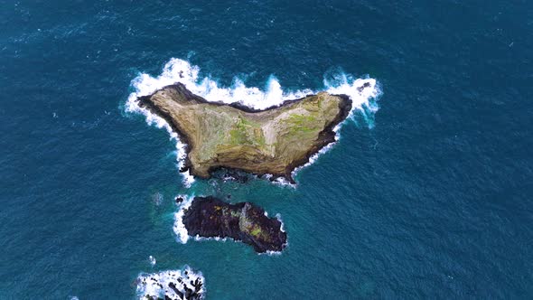 Top-down aerial view over rocky island, Ilheu Mole, Porto Moniz, Madeira alt