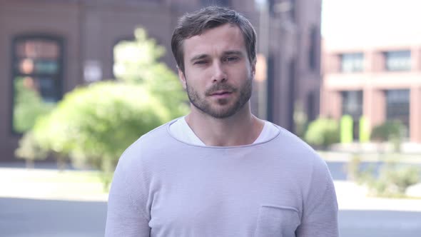 Portrait of Sad Handsome Man Looking at Camera alt