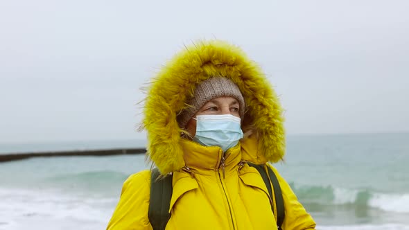 COVID19 Pandemic Coronavirus Senior Woman Tourist in Warm Jacket with a Backpack Travels and Walks