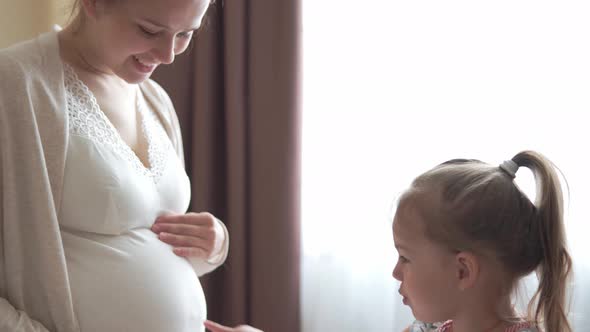 Pregnant Woman Feeling Happy at Home Taking Care of Child