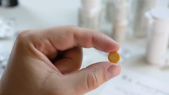 Unrecognizable Patient Hold Yellow Pill in Hand