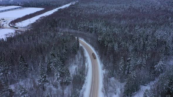 Flying Over a Highway in a Winter Forest