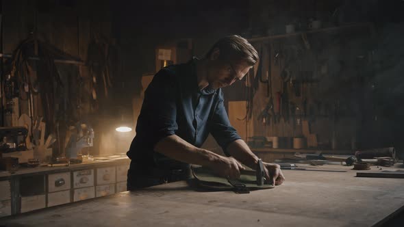 Professional Man Tailor Beating Off Seams on Handmade Leather Case Finishing Original Accessory alt