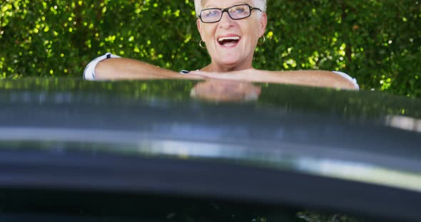 Senior woman standing near car alt