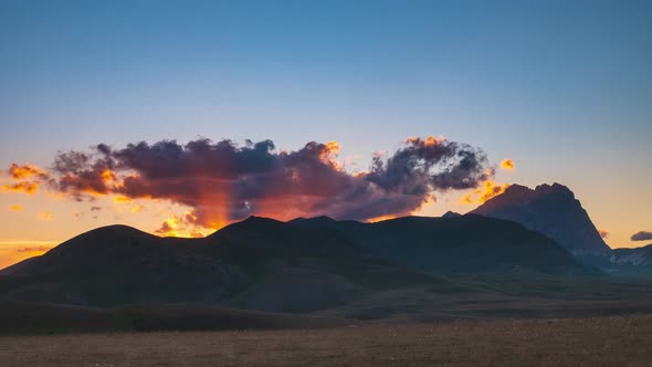 Time lapse: clouds moving in the sky, sunset view point over rocky mountains, highlands and pastures alt