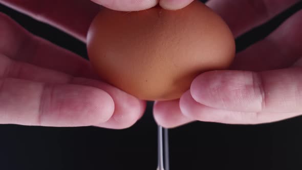 Closeup of an Egg in Hand Breaking Apart for Frying Slow Mo