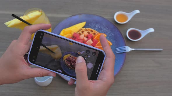 Female Hands Photographing Appetizing Food By Smartphone in the Restaurant alt