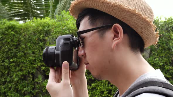 Rear Side View of Young Male Travel Photographer Tourist Taking Photos in Nature Scenery alt